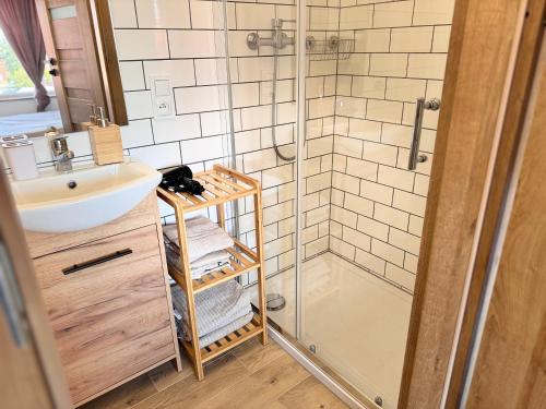 un baño con ducha y lavabo en Londynek, en Bydgoszcz
