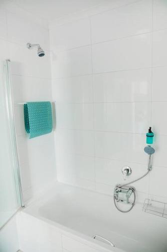 a bathroom with a shower with a mirror and a sink at Baydream Away in Cape Town