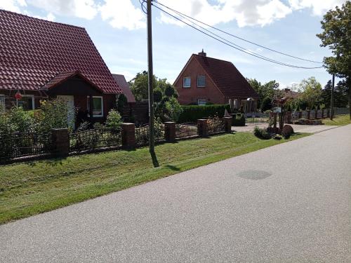 a residential street with houses and a fence at Auszeit-Schoenenwalde in Papenhagen