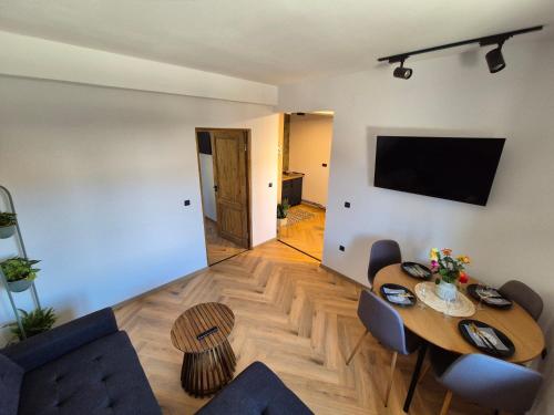 a living room with a table and a tv at Design Loft in Reşiţa