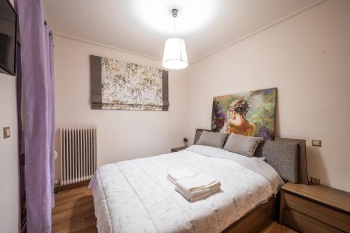 a bedroom with a bed and a painting on the wall at Loutraki Sea Sunset in Loutraki