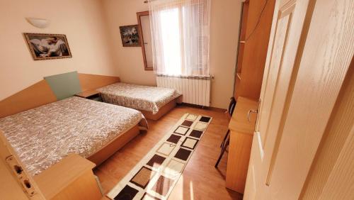 a small room with two beds and a window at Вила Боби in Tsigov Chark