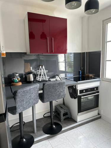 une cuisine avec des placards rouges et blancs et un comptoir dans l'établissement Sweet Home !, à Athis-Mons