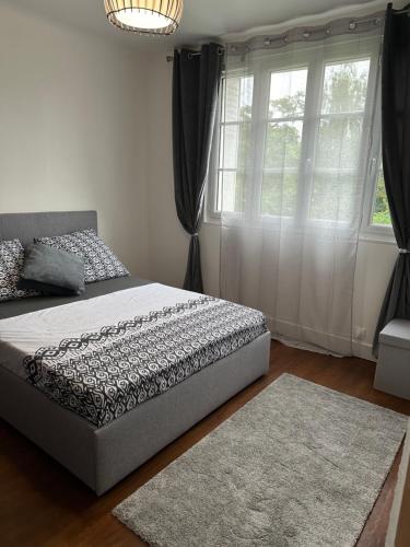 une chambre avec un lit et une grande fenêtre dans l'établissement Sweet Home !, à Athis-Mons