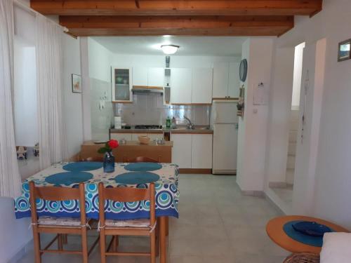 a kitchen with a table and chairs in a room at House ViEn in Nerezine