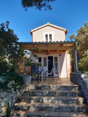 a house with a stone walkway to the front door at House ViEn in Nerezine