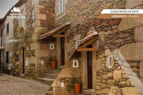 a stone building with stone steps next to a street at Casa Retiro de Xisto in Videmonte