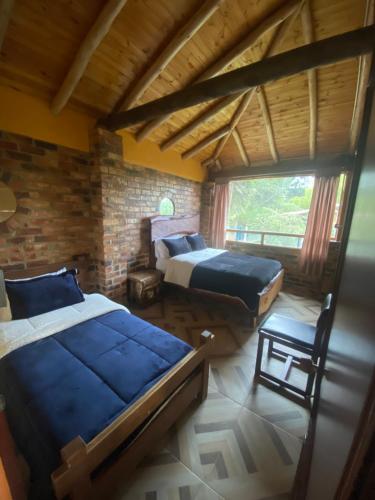 a bedroom with two beds and a window at Chalet Amadeus Guatavita in Guatavita