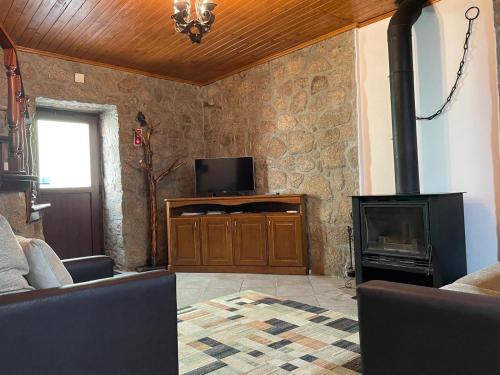 a living room with a tv and a fireplace at Casa Retiro de Xisto in Videmonte