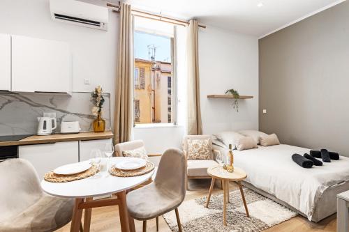 Ce petit appartement comprend un lit, une table et des chaises. dans l'établissement Maison dutto, à Menton