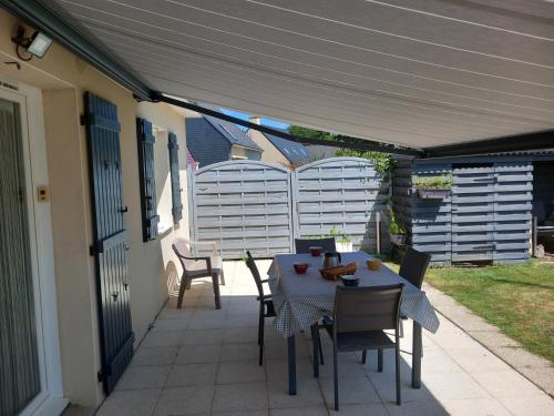 d'une terrasse avec une table et des chaises sous un auvent. dans l'établissement Maison familiale, proche mer, à Pénestin