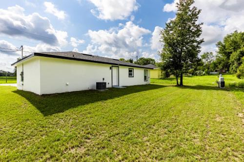 a white house with a large yard at Ocala Modern Oasis 5 minutes to World Equestrian Center in Ocala