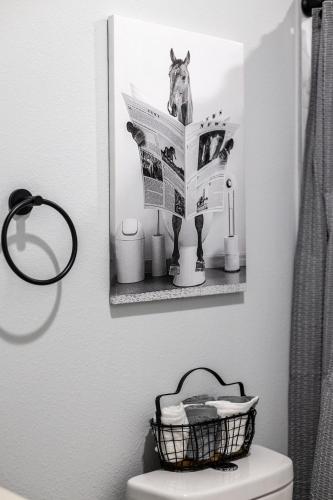 a bathroom with a newspaper on the wall above a toilet at Ocala Modern Oasis 5 minutes to World Equestrian Center in Ocala