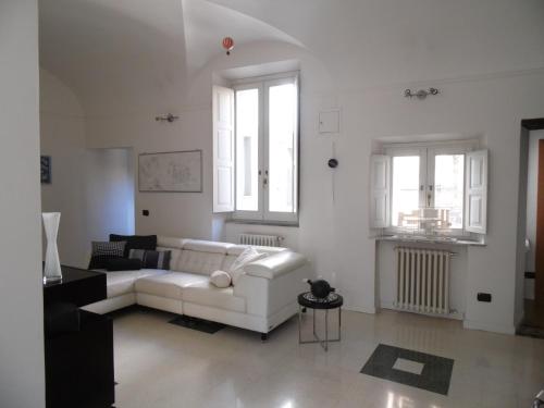 a living room with a white couch and two windows at Around the Medieval Tower in Viterbo