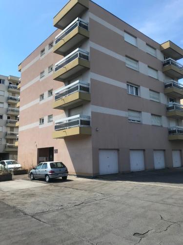 une voiture garée devant un immeuble dans l'établissement Momo, à Nancy