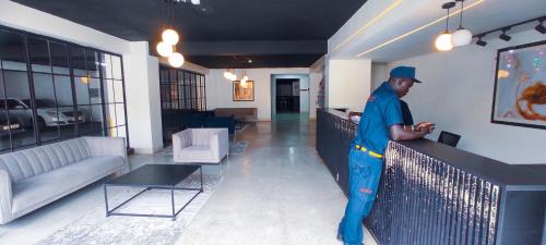 a man standing at a counter in a living room at Serene Hills Home in Nairobi