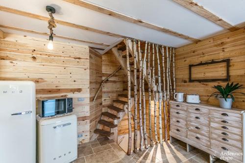 a kitchen with wooden walls and a refrigerator at Les Gîtes de Sprimont - Le Cottage in Sprimont