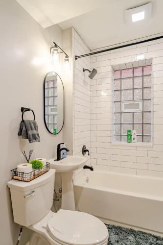 a white bathroom with a toilet and a sink at Stylish & Bright Gem Overlooks Lovely Park with Great Amenities in Chicago