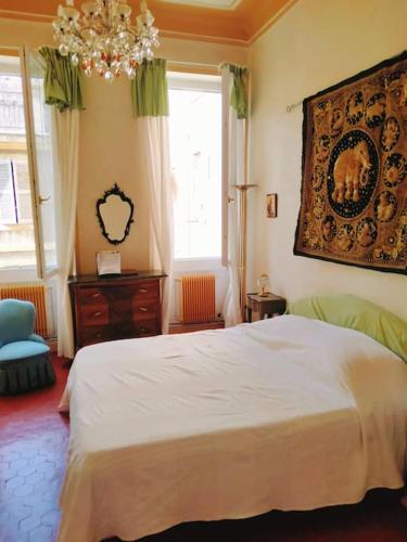 - une chambre avec un grand lit blanc et un lustre dans l'établissement Grand T5 bourgeois Canebiere, à Marseille