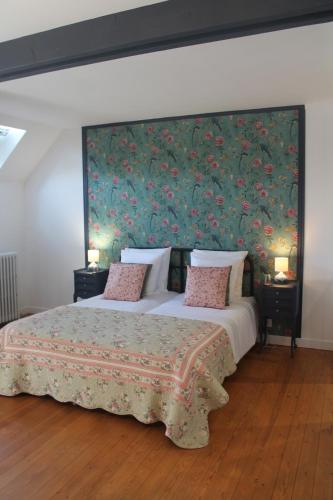 a bedroom with a large bed with a floral wallpaper at Les 13 lavoirs d'antan - chambre la belle époque in Saint-Pierre-Église