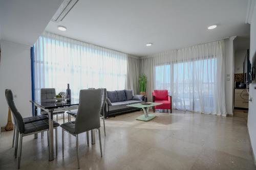 a living room with a couch and a table and chairs at Central Park Residence in Eilat
