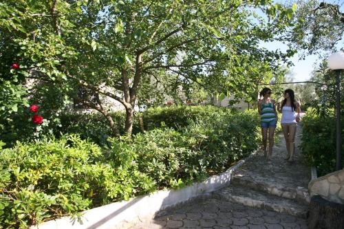 two women walking down a path in a garden at Tenuta Padre Pio in Vieste