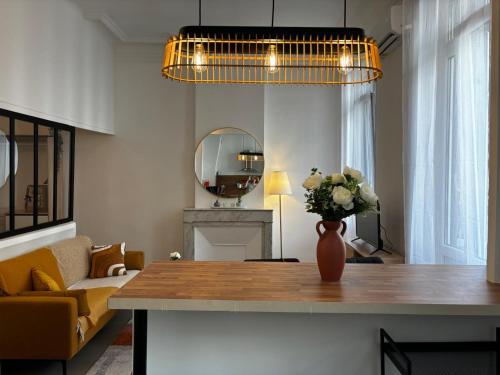 un salon avec une table avec un vase de fleurs dans l'établissement Confort et style en plein Marseille Type 2, à Marseille
