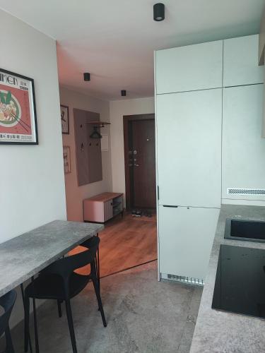 a kitchen with a table and a white refrigerator at Žemaičių 8 in Kretinga