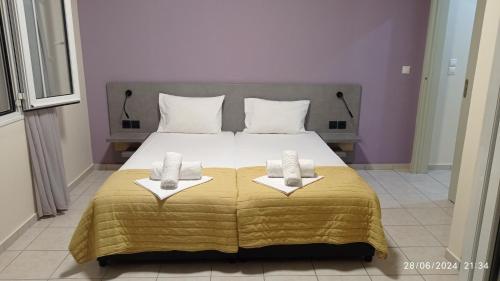 a bedroom with a large bed with two towels on it at Sunny Beach Apartments in Rethymno Town