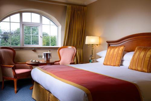 um quarto de hotel com uma cama e cadeiras e uma janela em Killarney Avenue em Killarney