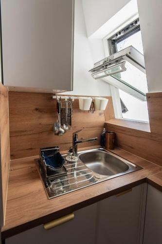 une petite cuisine avec un évier et une fenêtre dans l'établissement Welcome to Paris, à Paris