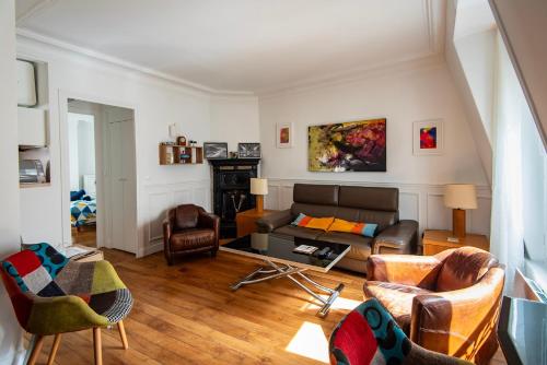 un salon avec un canapé et des chaises dans l'établissement Welcome to Paris, à Paris