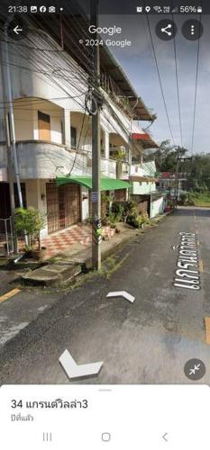 an empty street with white arrows on the side of a building at 34house in Betong