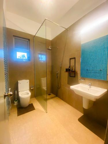 a bathroom with a shower and a toilet and a sink at TRES Galle in Galle