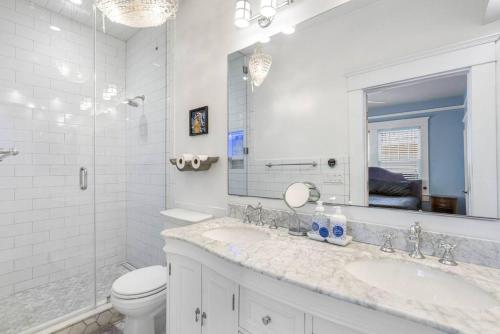 Un baño con lavabo, inodoro y espejo. en Spacious Hyde Park Retreat on Packwood, en Tampa