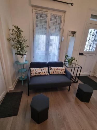 - un salon avec un canapé bleu et deux tabourets dans l'établissement Charmante maison proche de Paris, à LʼHay-les-Roses