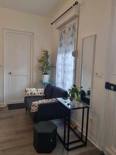 un salon avec un canapé et une table dans l'établissement Charmante maison proche de Paris, à LʼHay-les-Roses