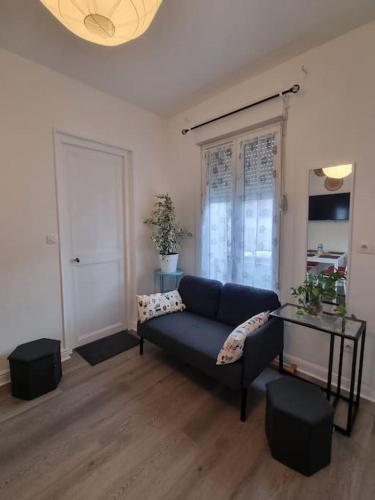 un salon avec un canapé bleu et une table dans l'établissement Charmante maison proche de Paris, à LʼHay-les-Roses