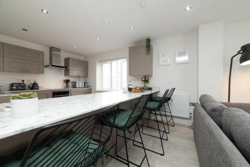a kitchen with a bar with chairs and a couch at Luxury Duplex 2-Bed Apartment Fruit Market Marina in Hull