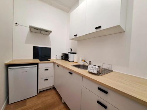 une cuisine avec des armoires blanches et un comptoir en bois dans l'établissement Appartement Vieux-Port, à Marseille