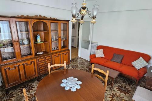 a living room with a red couch and a table at Caraluna Vacanze - Rapallo in Rapallo
