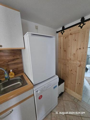 a kitchen with a white refrigerator and a sink at Bungalow ,, Zur langen Heide,, in Hildburghausen