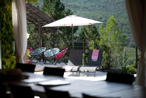 a group of chairs and an umbrella on a patio at Coste in Mollans-sur-Ouvèze