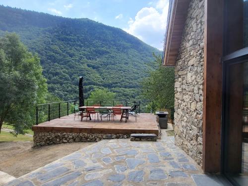 une terrasse en bois avec une table et des chaises dessus dans l'établissement Grange Los Mens, à Gèdre