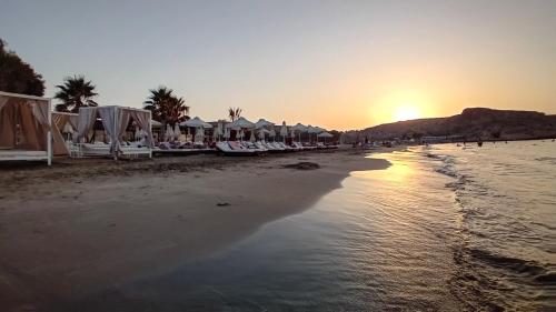 a beach with a bunch of umbrellas and the sunset at casa NEFELI in Karteros