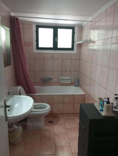 a bathroom with a tub and a toilet and a sink at NTARAS HOME in Pinakokhórion