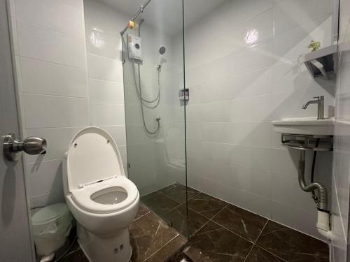 a bathroom with a toilet and a shower and a sink at The White Den Sukhumvit 44 in Bangkok