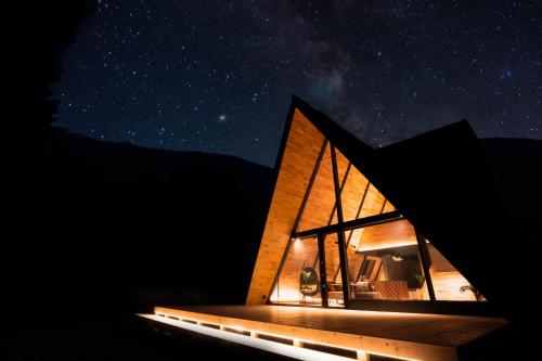 a glass house under the stars at night at A-frame箱根強羅 in Hakone