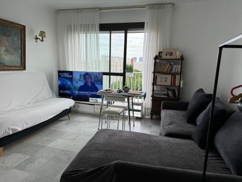 レ・リラにあるLilas houseのベッドとテレビのあるリビングルーム