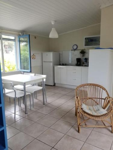 une cuisine avec une table, des chaises et un réfrigérateur dans l'établissement studio eucalyptus, à Canale-di-Verde